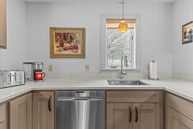 kitchen with stainless steel dishwasher, a sink, hanging light fixtures, and light countertops