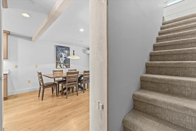 stairs featuring recessed lighting, beam ceiling, and wood finished floors
