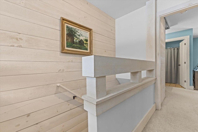 corridor featuring wood walls and carpet flooring