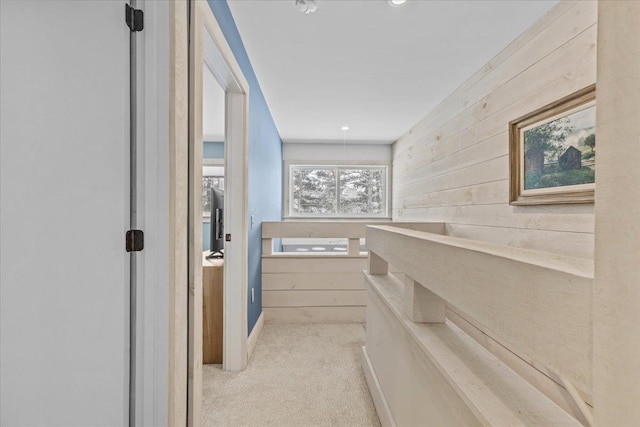 hall featuring carpet floors and wood walls