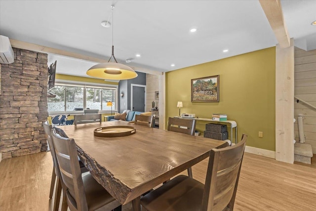 dining space with recessed lighting, baseboards, light wood finished floors, and a wall unit AC