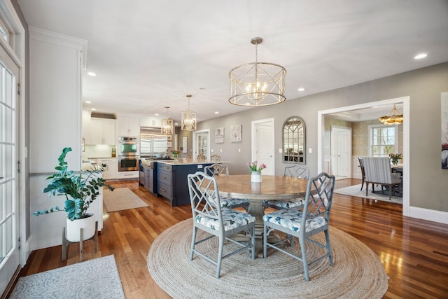dining area featuring an inviting chandelier, recessed lighting, and wood finished floors