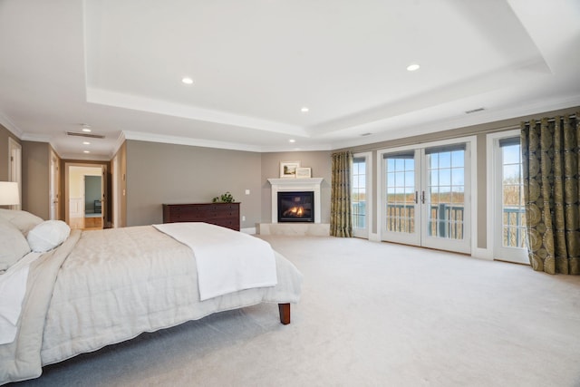 bedroom with access to outside, a tray ceiling, recessed lighting, and carpet flooring