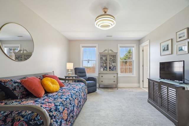 bedroom featuring carpet floors, baseboards, and multiple windows