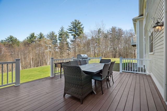 wooden deck featuring outdoor dining area, a yard, and area for grilling