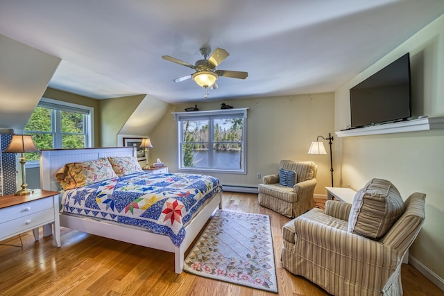 bedroom with wood finished floors, a ceiling fan, baseboards, and a baseboard heating unit