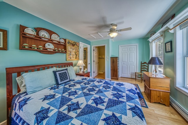bedroom with a ceiling fan, multiple windows, wood finished floors, and a baseboard radiator
