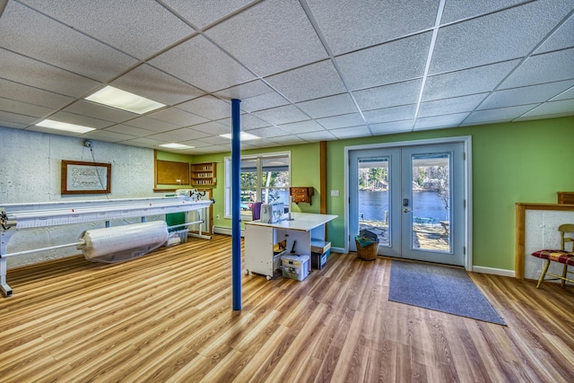 interior space featuring french doors, a baseboard radiator, baseboards, and wood finished floors