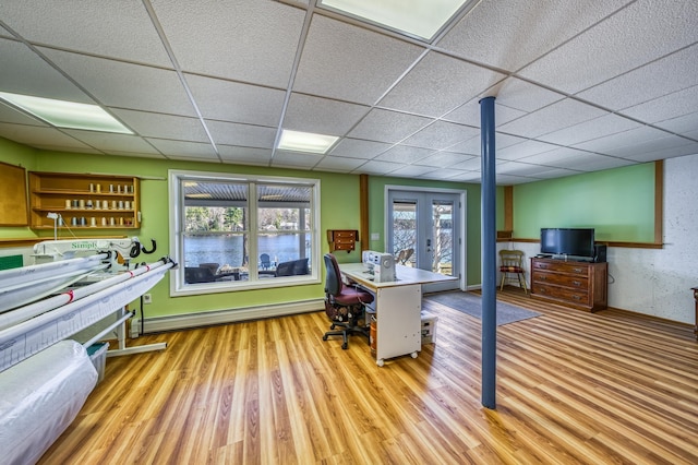office featuring baseboards, a baseboard radiator, wood finished floors, and a paneled ceiling