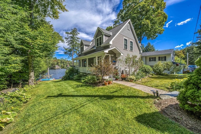 view of side of property featuring a lawn and a water view
