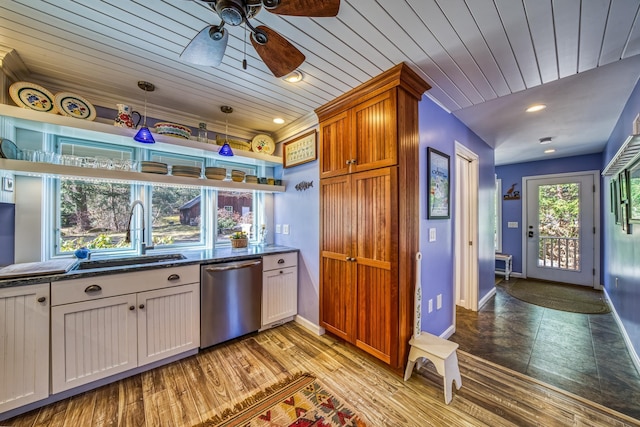 kitchen featuring baseboards, ceiling fan, a sink, dark stone countertops, and dishwasher