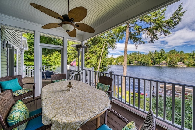 sunroom / solarium featuring a water view, ceiling fan, and outdoor dining space