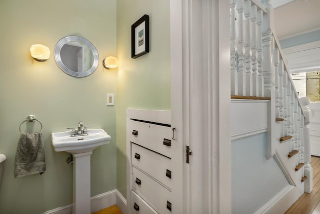 bathroom with baseboards, a sink, and wood finished floors