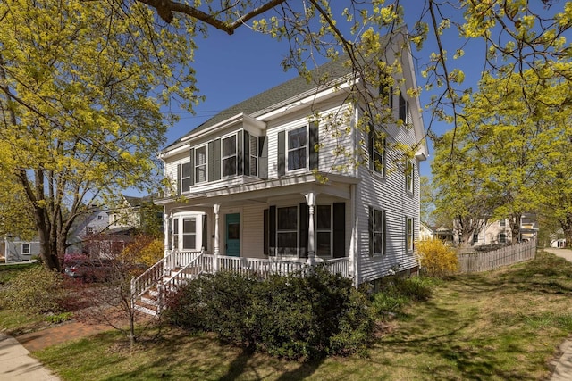 italianate house featuring a porch and fence