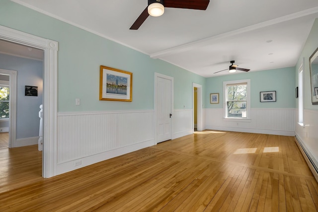 interior space with ceiling fan, wainscoting, light wood finished floors, and a baseboard radiator