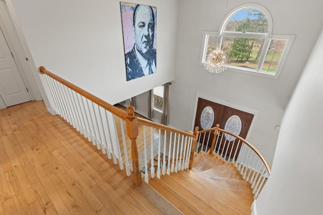 staircase with hardwood / wood-style flooring and a towering ceiling