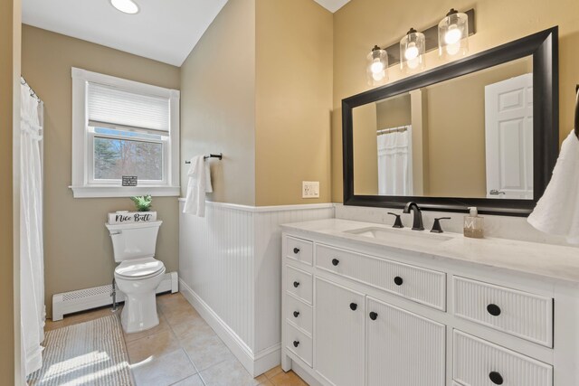 full bath with baseboard heating, wainscoting, vanity, tile patterned floors, and toilet