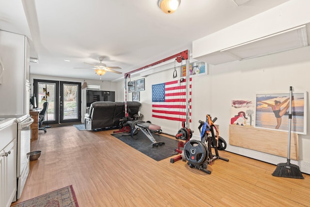 workout room featuring attic access, ceiling fan, and wood finished floors