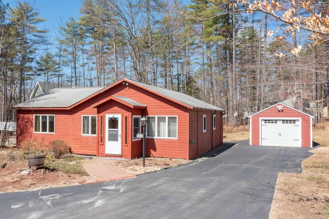 view of front facade with driveway, an outbuilding, and a garage