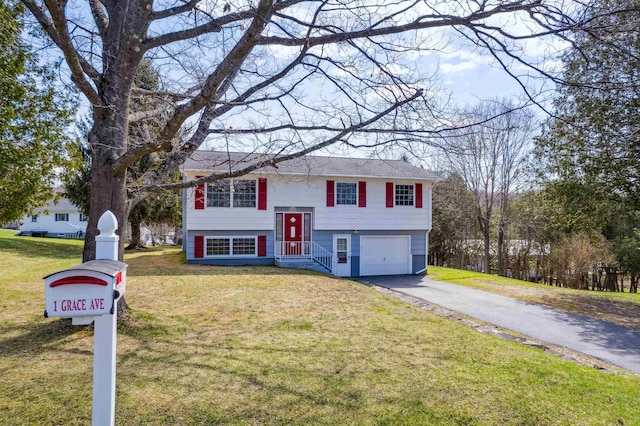 raised ranch featuring a garage, driveway, and a front yard