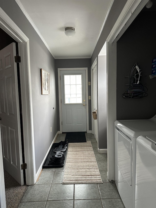 doorway to outside featuring crown molding, baseboards, and washing machine and dryer