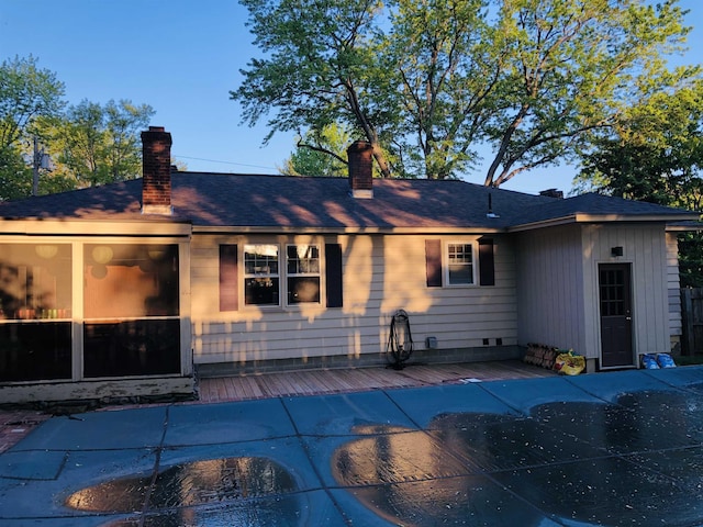 rear view of house featuring a wooden deck and a chimney