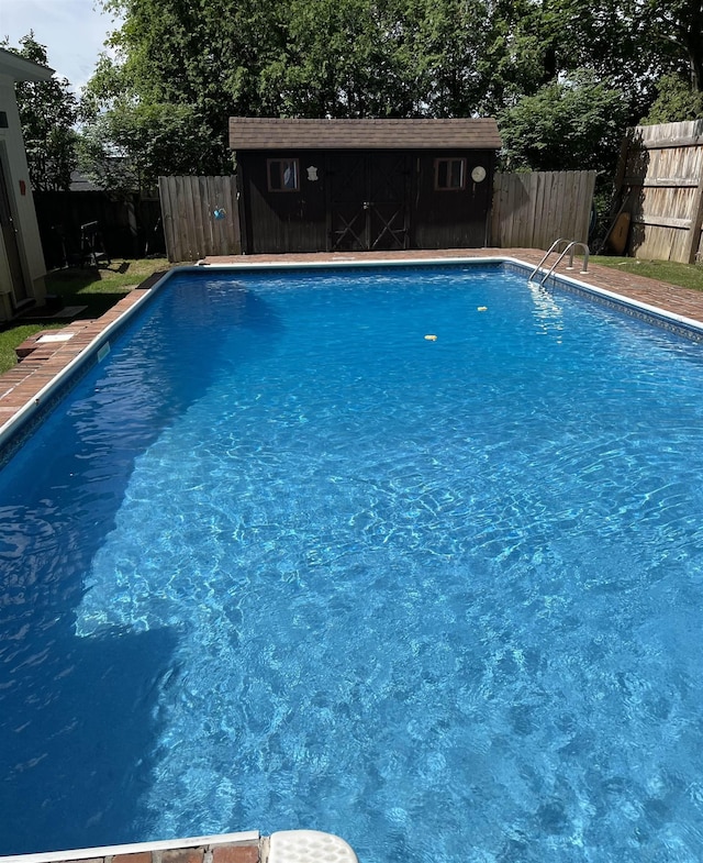 view of swimming pool with fence, a fenced in pool, and an outdoor structure