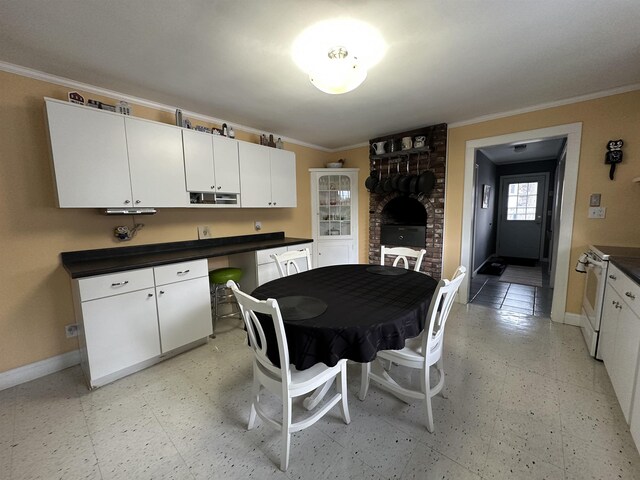 kitchen featuring crown molding, baseboards, and dark countertops