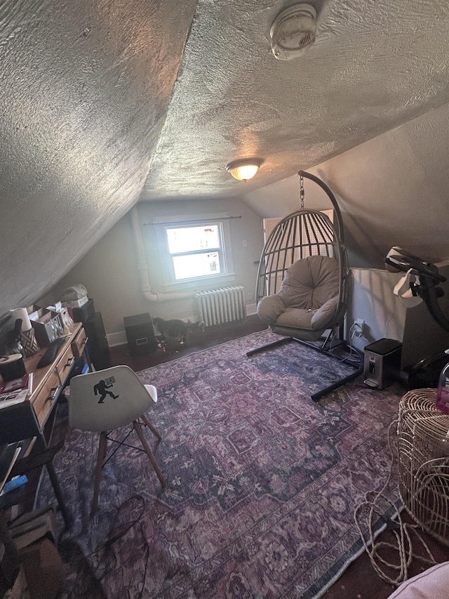interior space with radiator, carpet, vaulted ceiling, and a textured ceiling
