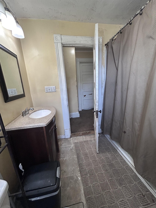 full bath with vanity, baseboards, and curtained shower