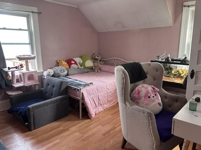 bedroom with lofted ceiling and light wood-style floors