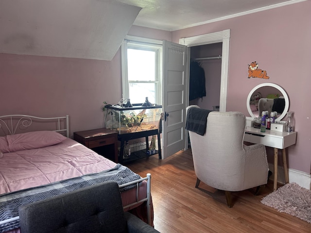 bedroom featuring a closet, ornamental molding, and wood finished floors