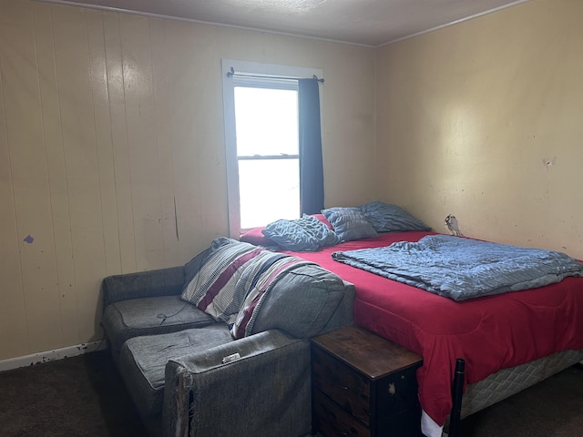 carpeted bedroom with wood walls