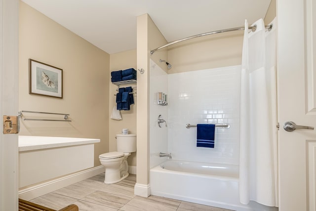 bathroom with baseboards, toilet, and shower / tub combo with curtain