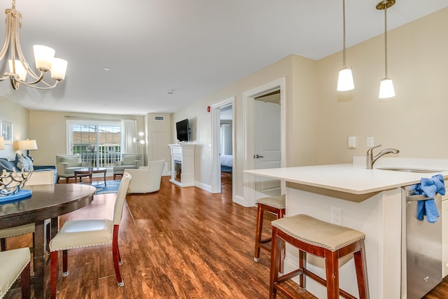 dining room featuring baseboards, dark wood-style flooring, a chandelier, and a fireplace