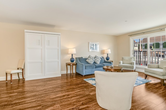 living room with baseboards and dark wood-style floors