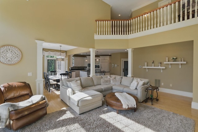 7 Champagne Ter, Bedford, NH 03110 - living room with ornate columns, a high ceiling, baseboards, and wood finished floors