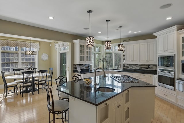 7 Champagne Ter, Bedford, NH 03110 - kitchen with light wood-style floors, a sink, appliances with stainless steel finishes, and glass insert cabinets