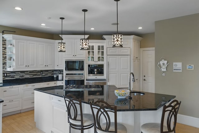 7 Champagne Ter, Bedford, NH 03110 - kitchen with white cabinets, open shelves, light wood finished floors, a kitchen breakfast bar, and an island with sink