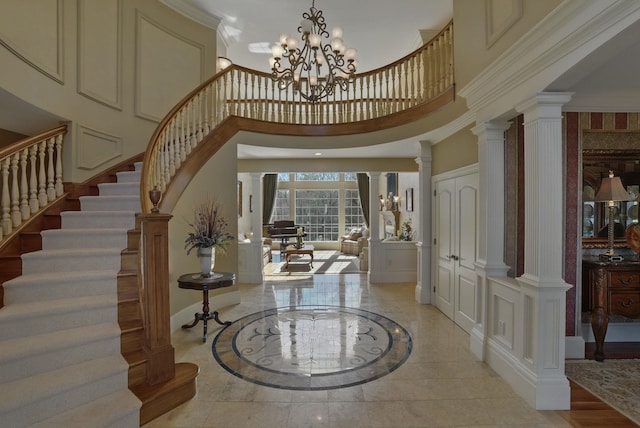 7 Champagne Ter, Bedford, NH 03110 - foyer featuring decorative columns, a chandelier, a high ceiling, a decorative wall, and stairs