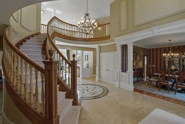 7 Champagne Ter, Bedford, NH 03110 - entrance foyer featuring ornamental molding, a towering ceiling, a decorative wall, stairway, and a notable chandelier