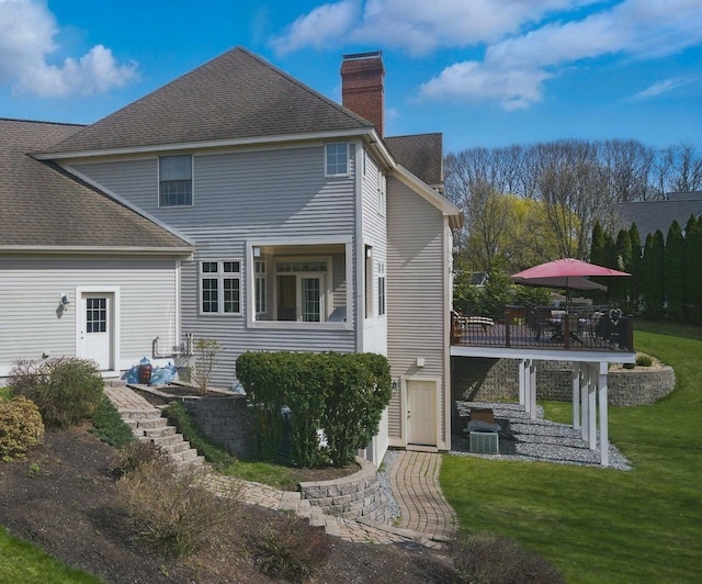 7 Champagne Ter, Bedford, NH 03110 - back of property with a wooden deck, cooling unit, a chimney, a shingled roof, and a yard