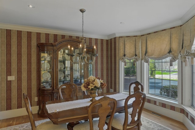 7 Champagne Ter, Bedford, NH 03110 - dining room featuring visible vents, crown molding, an inviting chandelier, wallpapered walls, and light wood-style flooring