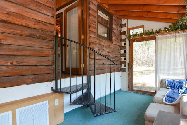 entryway with carpet floors, lofted ceiling with beams, stairs, and visible vents