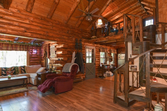 living area featuring stairway, wooden ceiling, high vaulted ceiling, and a healthy amount of sunlight