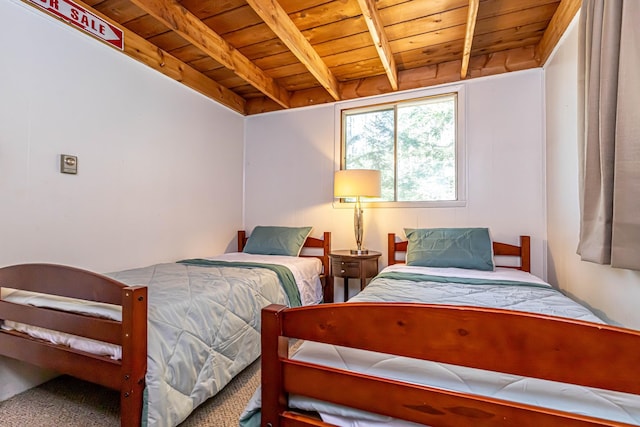 bedroom featuring carpet floors, beamed ceiling, and wood ceiling