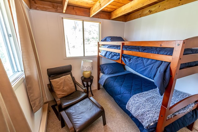 bedroom featuring wooden ceiling, multiple windows, and carpet