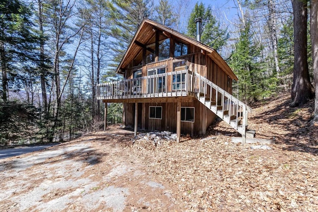 rear view of property featuring stairs and a deck