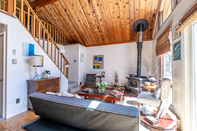 living room featuring stairs, wood ceiling, and a wood stove