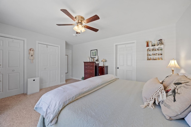 bedroom featuring carpet flooring, multiple closets, and a ceiling fan